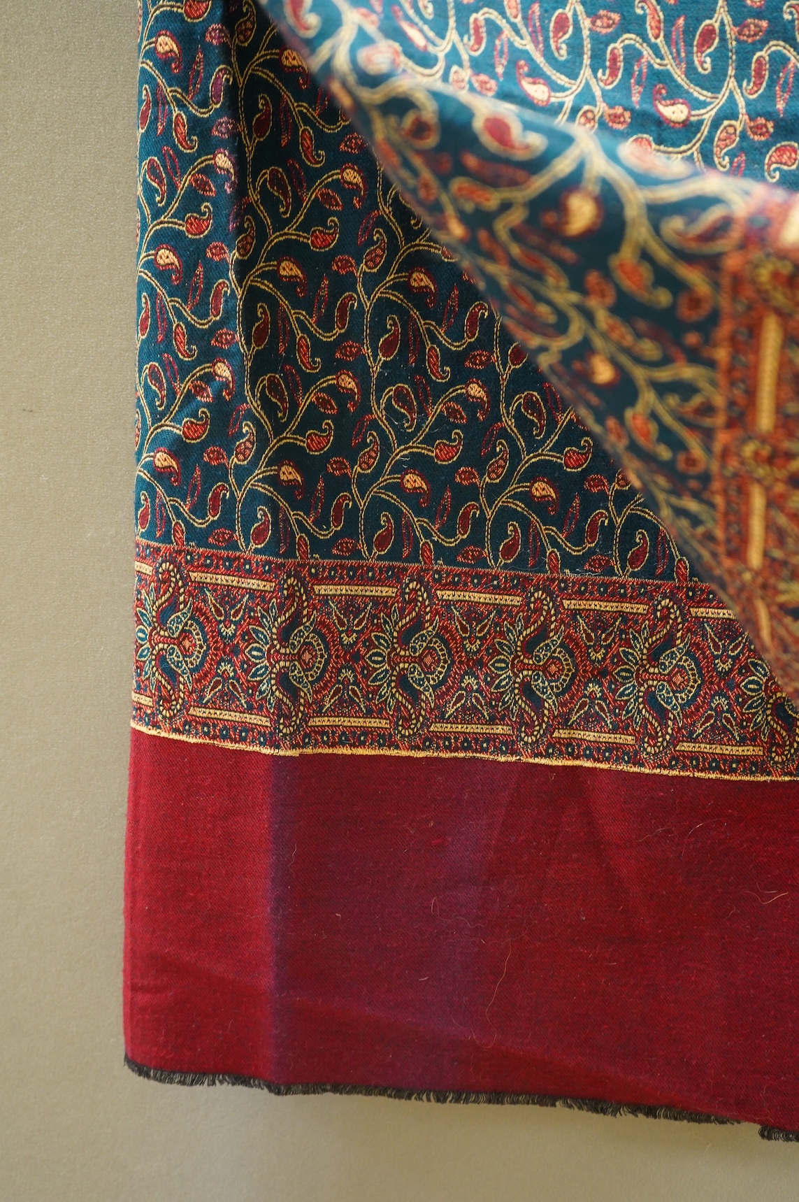 A 19th century printed silk shawl and a printed paisley shawl, together with a late 20th century wool machine woven stole with Oswal label. Condition - the two 19th century shawls are damaged but useful for TV and film c